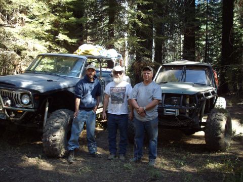 1982 Toyota 4Runner - Three men pose with two heavily modified off-road vehicles in a forest setting.