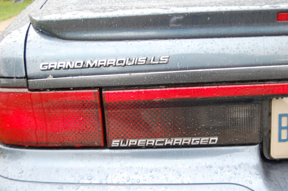 Rear of a blue Grand Marquis LS with a Supercharged badge