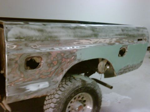 1979 Ford F-250 - This 1979 Ford F-250 shows its rear fender area undergoing bodywork, with primer and filler visible.