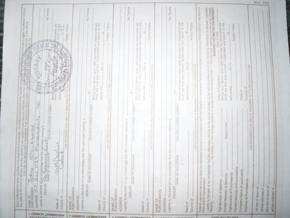 North Carolina vehicle title assignment form with handwritten entries and notary stamp