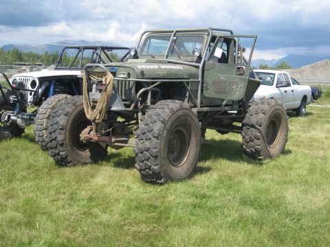 1990 Ford F-250 - Modified off-road jeep with "SWAMP DONKEY" text, seen with other vehicles on a grassy field.