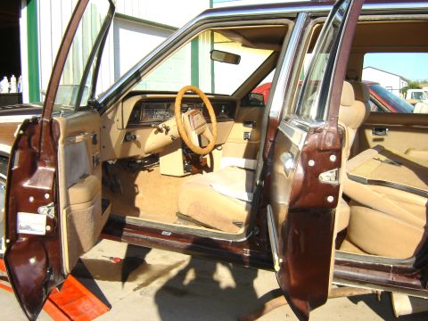1984 Ford LTD - The interior of a brown station wagon is shown with tan upholstery and wood paneling details.