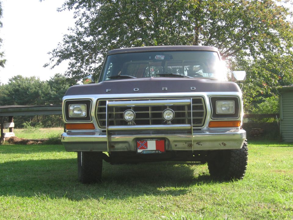 Front view of brown Ford pickup with grille guard and FORD lettering on hood