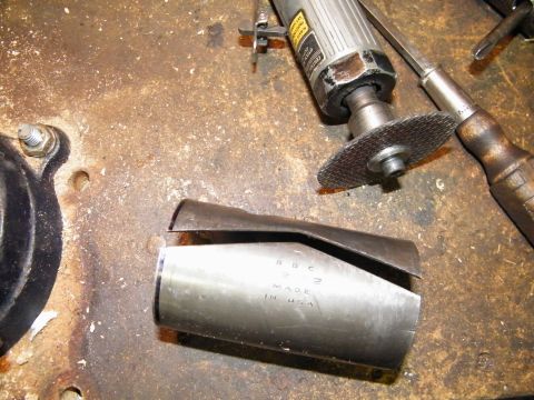 1912 Ford Model T - A metal part sits on a workbench next to a cutting tool and a screwdriver, with text indicating it was made in the USA.