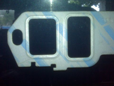 1995 Ford Bronco - A close-up view of an engine gasket, showing its shape and design details.