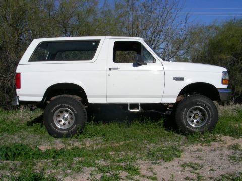1996 Ford Bronco - This white 1996 Ford Bronco is shown from the side, lifted with large tires.