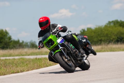 2001 Kawasaki KZ1000-A1 - Riders compete on a track, with the lead motorcycle a distinctive green fairing and a rider in a red helmet.