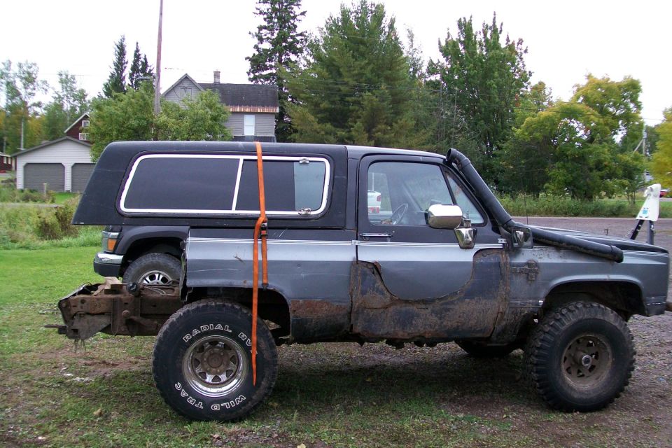 Modified Chevrolet K5 Blazer with snorkel, lifted, and a second vehicle partially visible behind it
