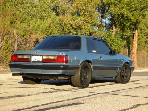 1990 Ford Mustang - This 1990 Ford Mustang coupe is shown from the rear three-quarter angle, aftermarket wheels and a blue finish.