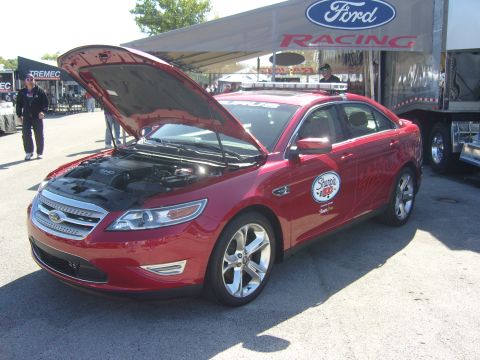 2007 Ford Mustang - Red Ford sedan with hood open at a Ford Racing event.