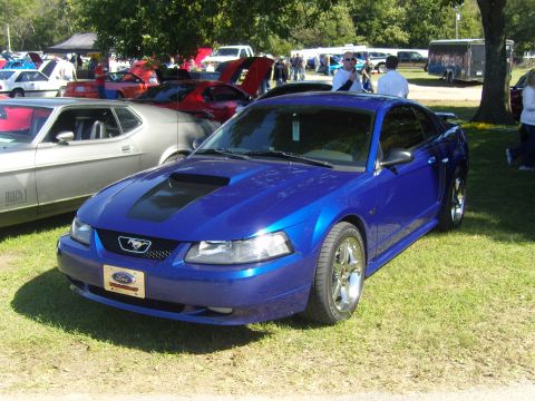 2007 Ford Mustang - A blue 2007 Ford Mustang is parked on the grass at an outdoor car show.