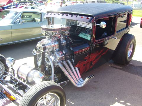 2007 Ford Mustang - Custom hot rod with a prominent supercharger and side pipes, parked next to another vehicle.
