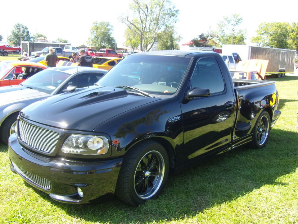 Black Ford F-150 Lightning pickup truck with a scooped hood and custom grille