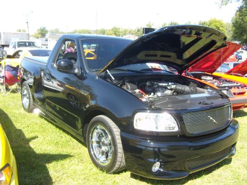 2007 Ford Mustang - A black 2007 Ford F-150 Lightning pickup truck is displayed with its hood open, revealing the engine compartment.
