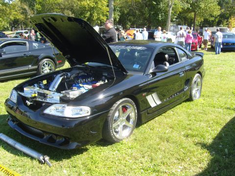 2007 Ford Mustang - A modified black Ford Mustang is displayed with its hood up, revealing engine components.