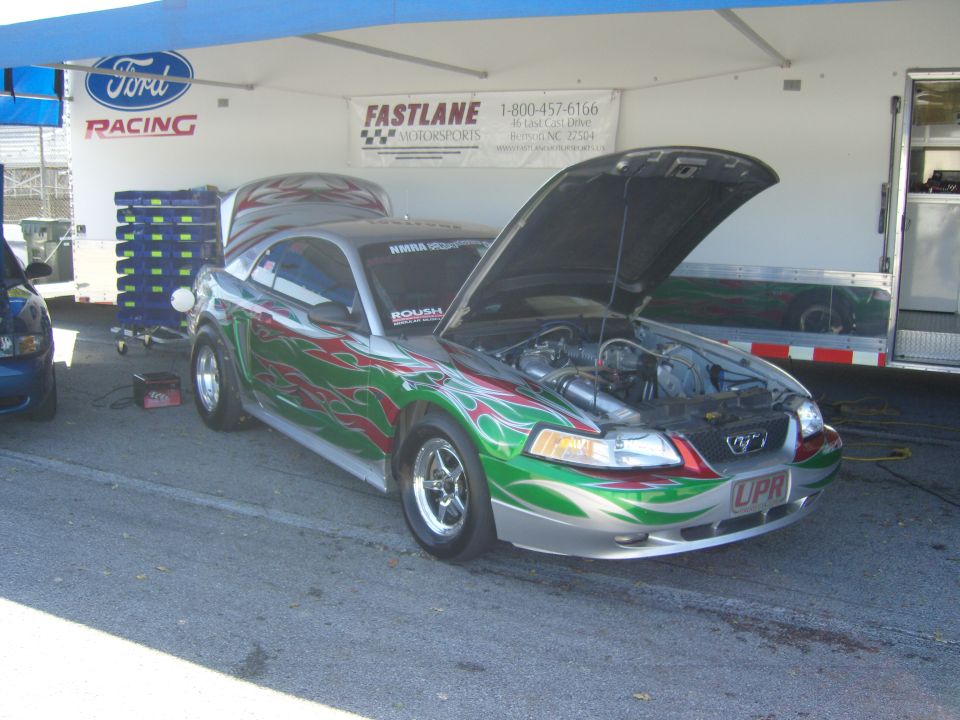 Customized silver and green flame Ford Mustang with hood open, UPR license plate