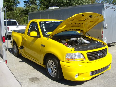 2007 Ford Mustang - This yellow 2007 Ford F-150 Lightning pickup truck is displayed with its hood open, revealing the engine and supercharger.
