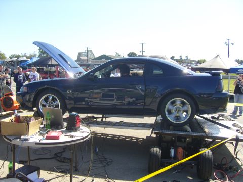 2007 Ford Mustang - A dark blue Ford Mustang GT is on a dynamometer with its hood open.