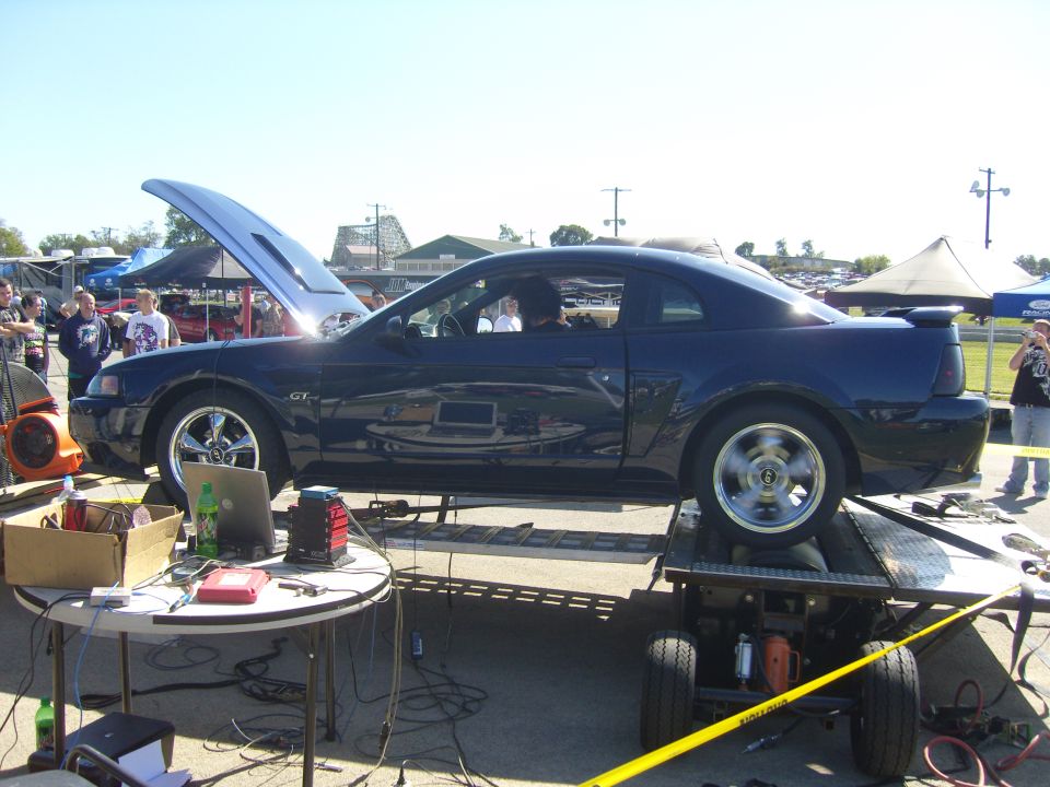 Dark blue Ford Mustang GT on a dynamometer, hood open, side view