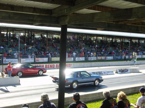 2007 Ford Mustang - A blue 1987 Ford Mustang competes in a drag race, with spectators in the background.
