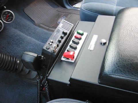1985 Ford Bronco - Interior view of a vehicle's center console, a CB radio and a panel of auxiliary buttons.