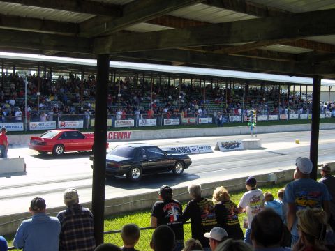 2007 Ford Mustang - Cars compete on a drag strip with a large crowd watching from the bleachers.