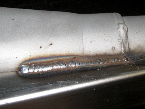 1996 Ford Bronco - A section of a metal tube shows a welded seam with rainbow discoloration and small pits.