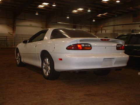 2000 Ford Crown Victoria - Rear view of a white Chevrolet Camaro, likely from the late 1990s, parked inside a building.