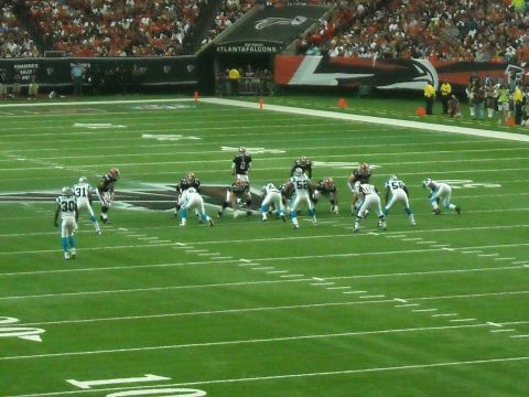 1979 Ford F-150 - A football game is underway with players on the field and fans in the stands.