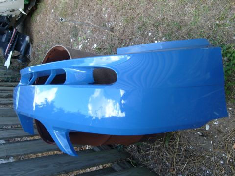 1992 Ford Bronco - A blue car bumper with distinctive vents is shown outdoors.