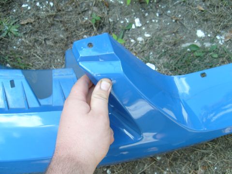 1992 Ford Bronco - A blue bumper part is shown, with a hand holding a section of it.