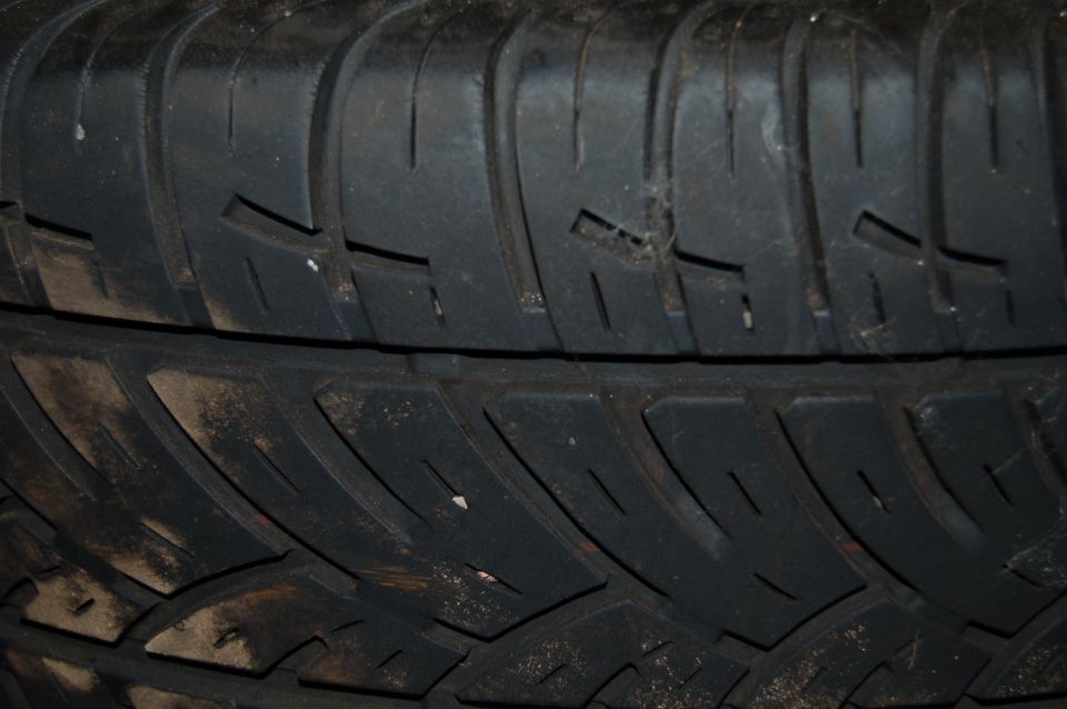 Close-up of tire tread pattern with dirt