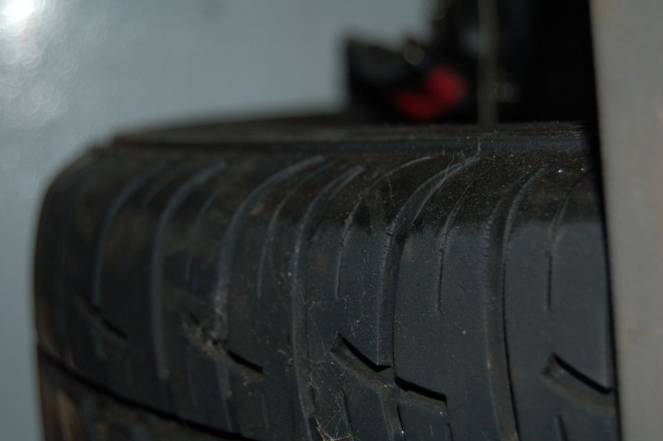 Tire tread detail with visible wear and minor damage