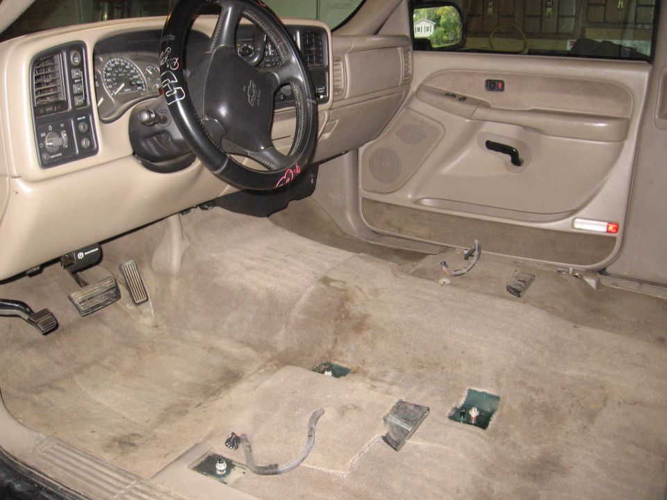 GM truck interior with carpet removed showing bare floor and seat brackets