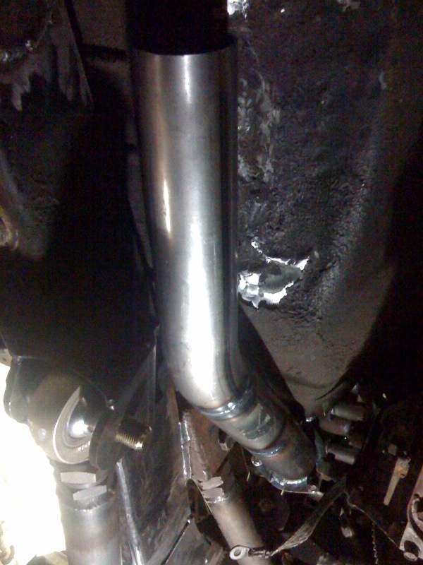 Custom exhaust pipe installation on a vehicle underside