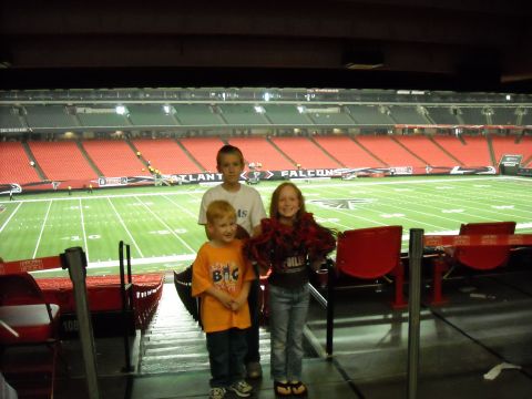 1979 Ford F-150 - Children pose for a photo in stadium seats with the football field visible.