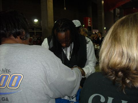 1979 Ford F-150 - A crowd of people are gathered, with one individual signing autographs. Text is visible on a gray shirt.