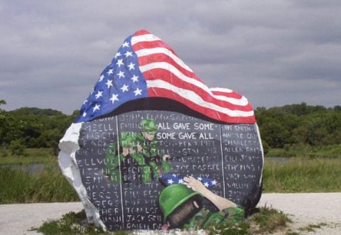 1987 Ford Bronco - A large roadside boulder painted as a veterans memorial, with an American flag draped across the top, a black wall of hand-lettered service…