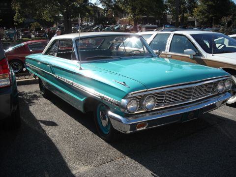 1979 Ford F-150 - A turquoise 1962 Ford Galaxie coupe is parked at an outdoor event with other vehicles visible.