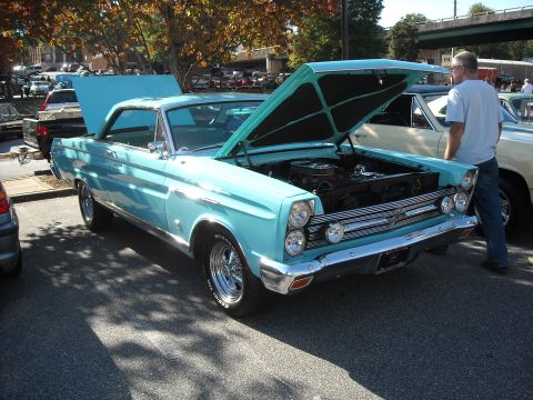 1979 Ford F-150 - A light blue 1966 Mercury Comet Cyclone is displayed with its hood open at an outdoor event.