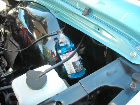 1979 Ford F-150 - Close-up of an engine bay shows a bottle of blue fluid with a GM logo and instructions.
