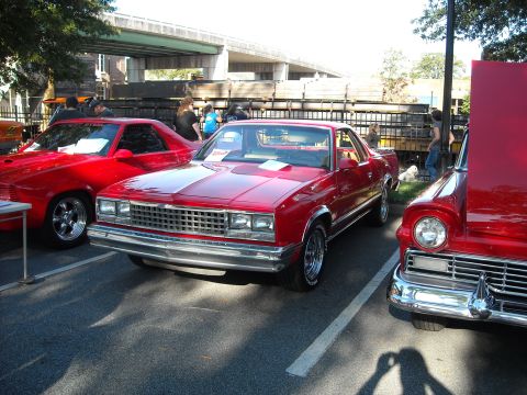 1979 Ford F-150 - A red coupe utility vehicle is parked at a car show, with other vehicles nearby.