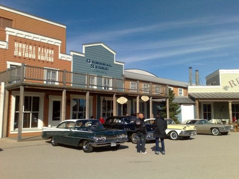 1991 Ford LTD Crown Victoria - Several classic cars are parked in front of buildings designed in an old west style.