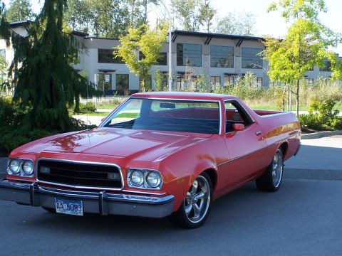 1973 Ford Ranchero - A red 1972 Ford Ranchero is shown from a three-quarter front angle in front of a contemporary building.