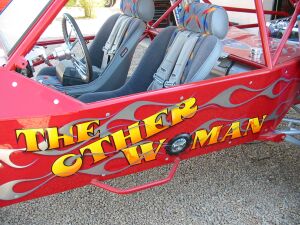 1993 Ford Taurus - A custom dune buggy with flame graphics and the name "The Other Woman" painted on its side.