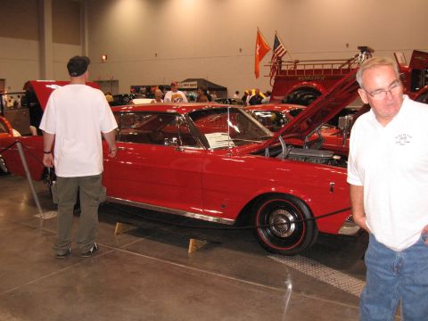 1968 Shelby GT500 - A red 1966 Ford Galaxie 500 is displayed with its hood open at an indoor car show.