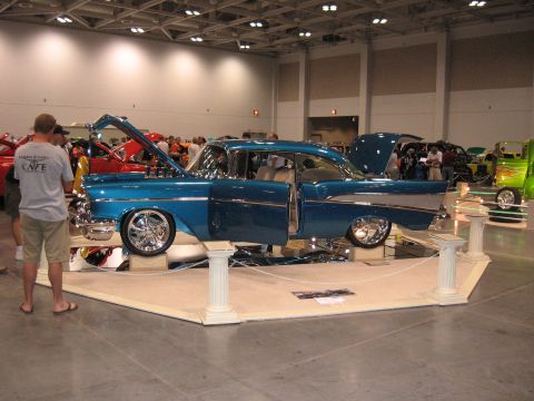 1968 Shelby GT500 - A custom blue coupe is displayed at a car show with its hood and doors open.