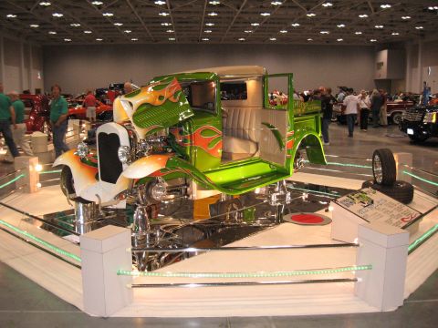 1968 Shelby GT500 - A custom hot rod truck is displayed indoors with its doors open, its flame paint job and detailed interior.
