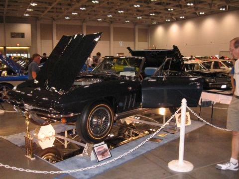 1968 Shelby GT500 - A dark blue convertible is displayed with its hood and door open at a car show.