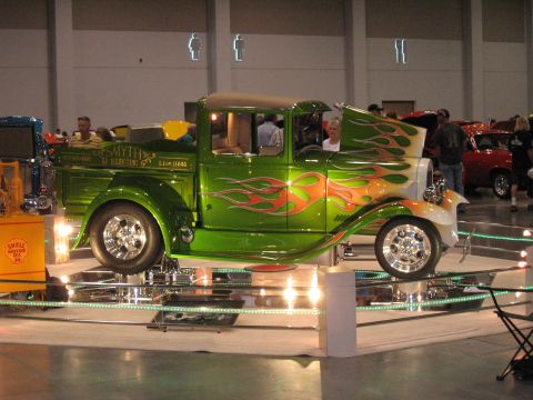 1968 Shelby GT500 - A custom green 1946 pickup truck with flame graphics is showcased at a car show.